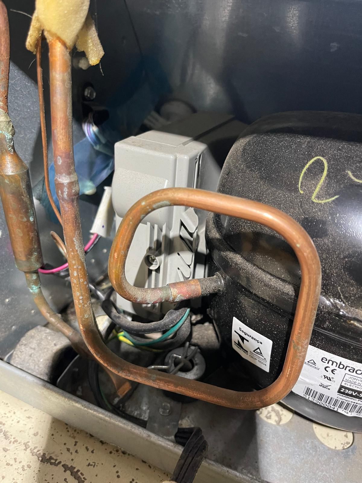 Copper tubing and refrigerator components in a tight space.