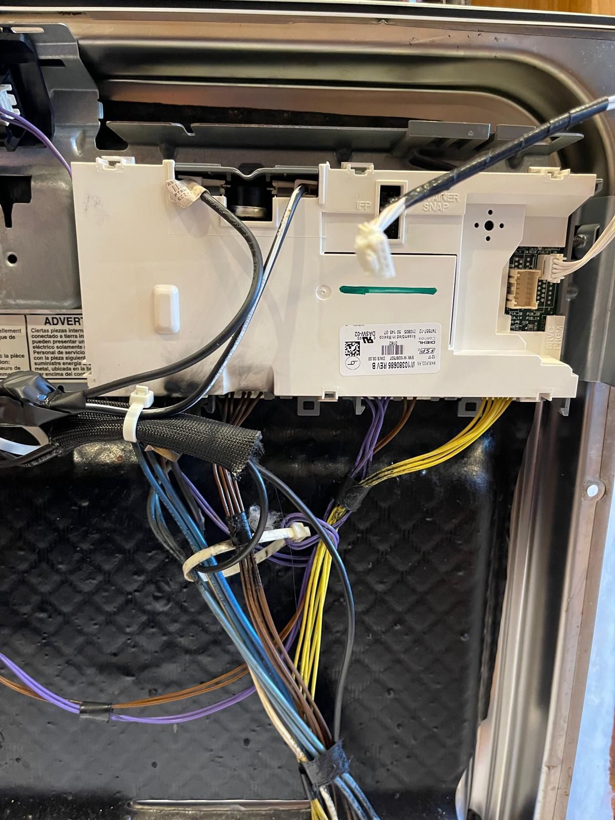 Dishwasher control panel with wires and circuit boards, inside of dishwasher.