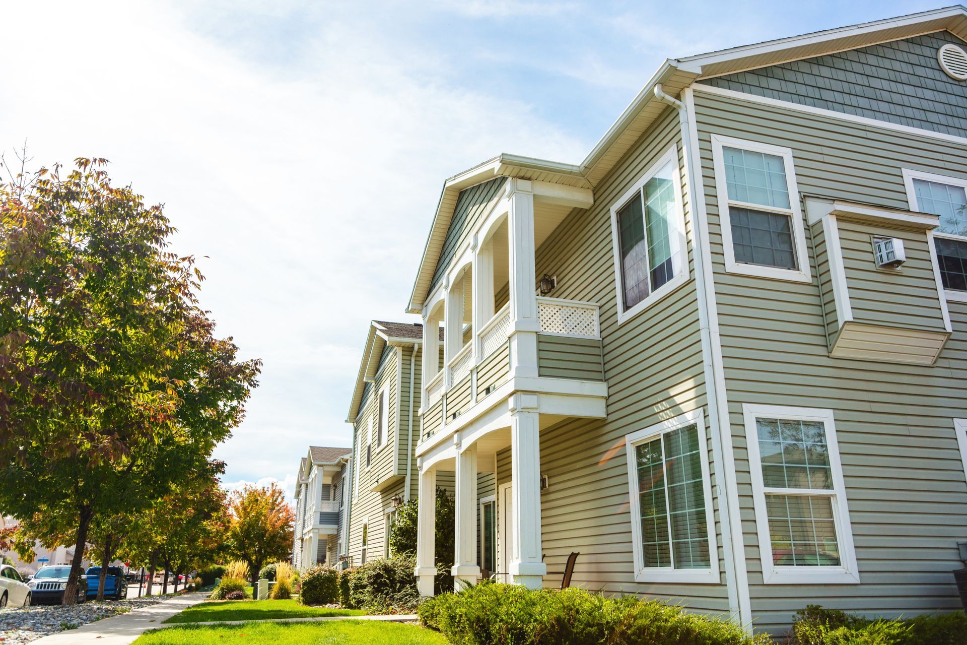 Exterior photo of a nice two-story residential building with columns and balcony