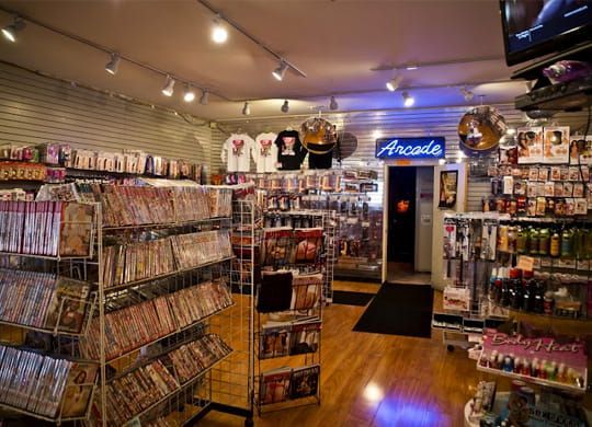 Packed arcade and collectibles store interior with shelves of merchandise and a lit arcade sign.