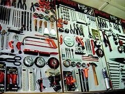 Herramientas dispuestas en una exhibición de pared, incluidos destornilladores, sierras y llaves inglesas.