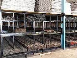 Barras y tubos de metal organizados en estanterías en un almacén.