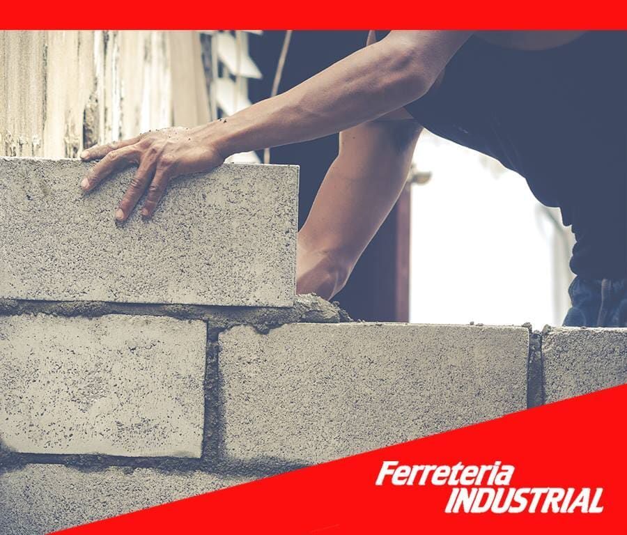 Obrero colocando bloques de hormigón, aplicando mortero.