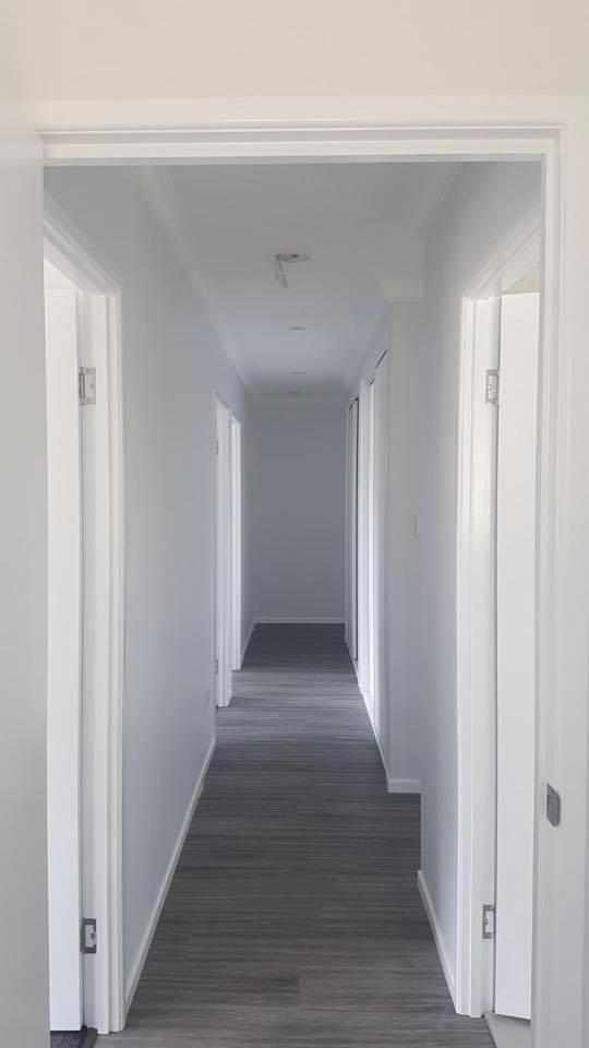 A Long Hallway with White Walls and Wooden Floors in A House — Allman's Painting in Monkland, QLD