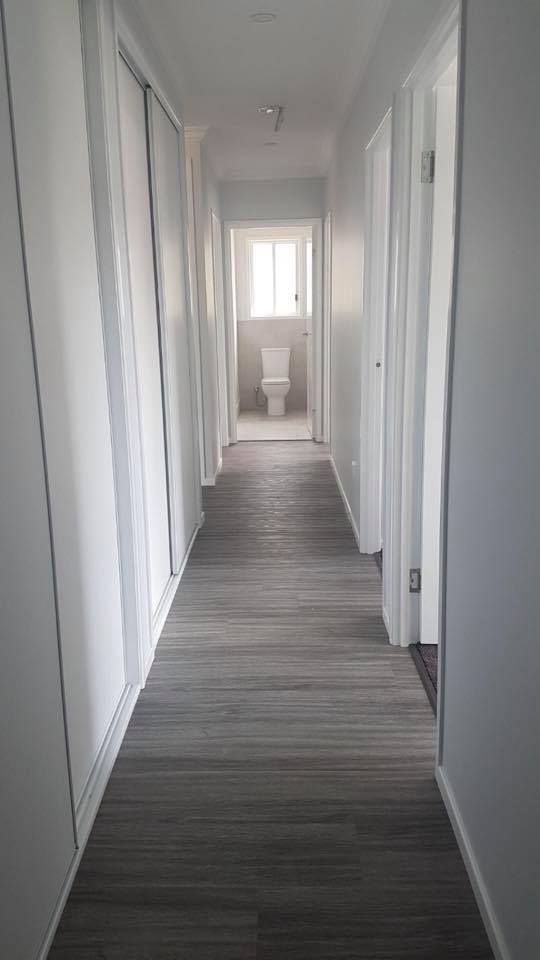 Long, Narrow Hallway With Gray Wood-look Flooring — Allman's Painting in Cooroy, QLD