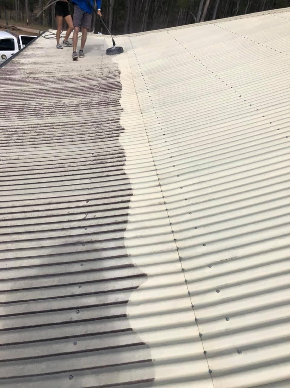 A Man Is Cleaning the Roof of A Building with A Broom — Allman's Painting in Monkland, QLD