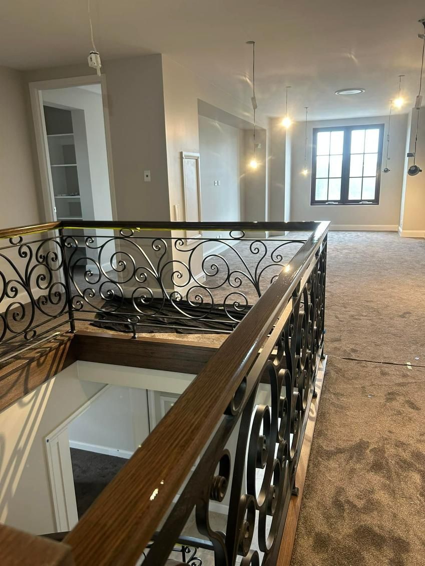 A Staircase with A Wrought Iron Railing in A House — Allman's Painting in Monkland, QLD