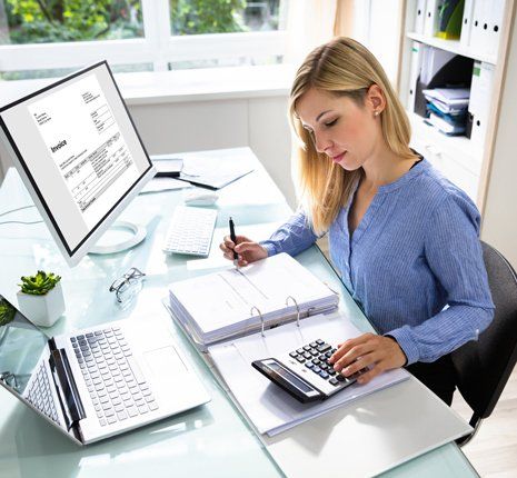 Payroll-Services — Young Businesswoman Calculating Bill in Office in Northfield, OH