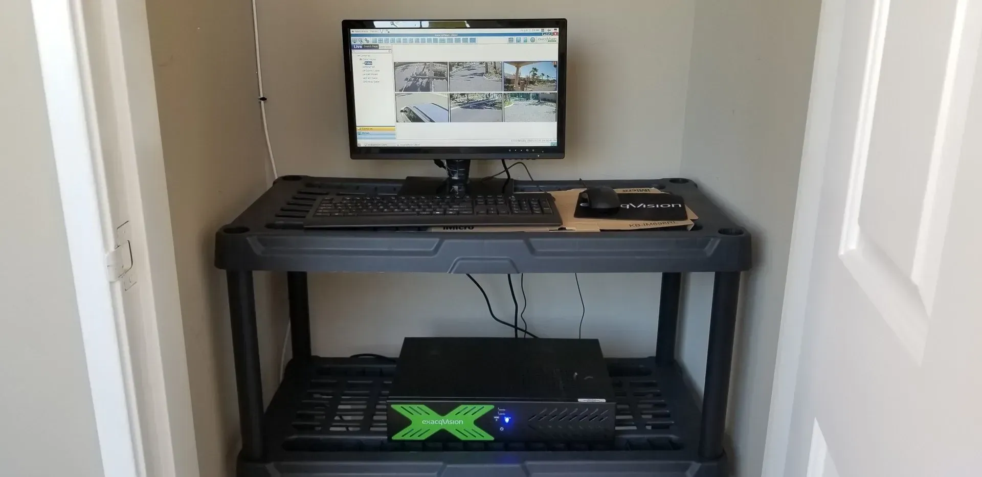 A computer is sitting on top of a shelf in a closet