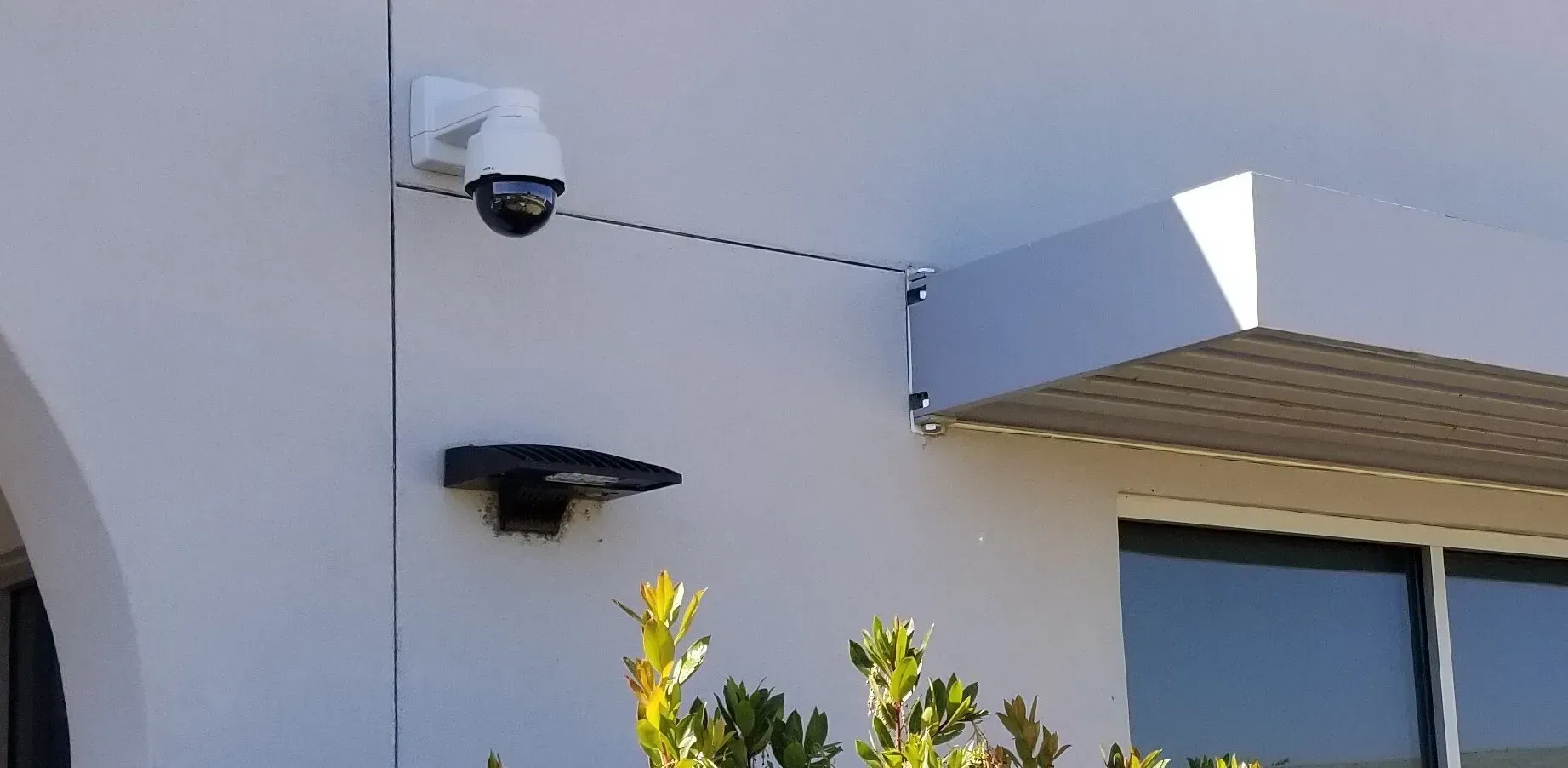 A security camera is mounted on the side of a building.