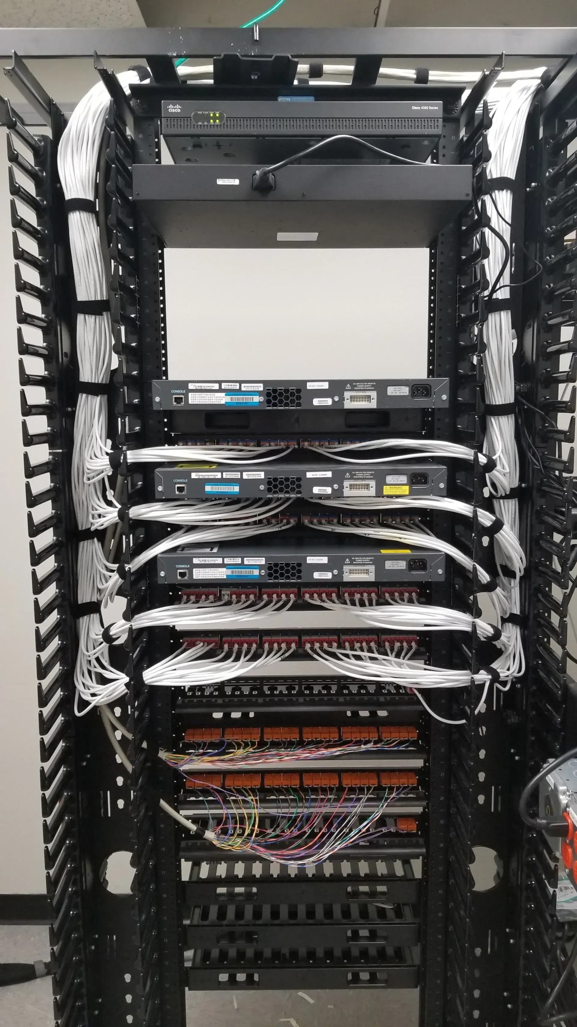 A server rack with a lot of wires coming out of it.