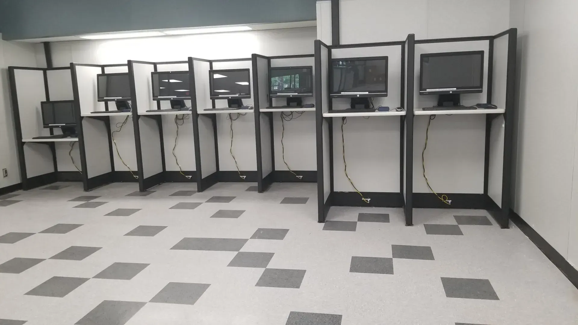 A row of computer cubicles with a checkered floor