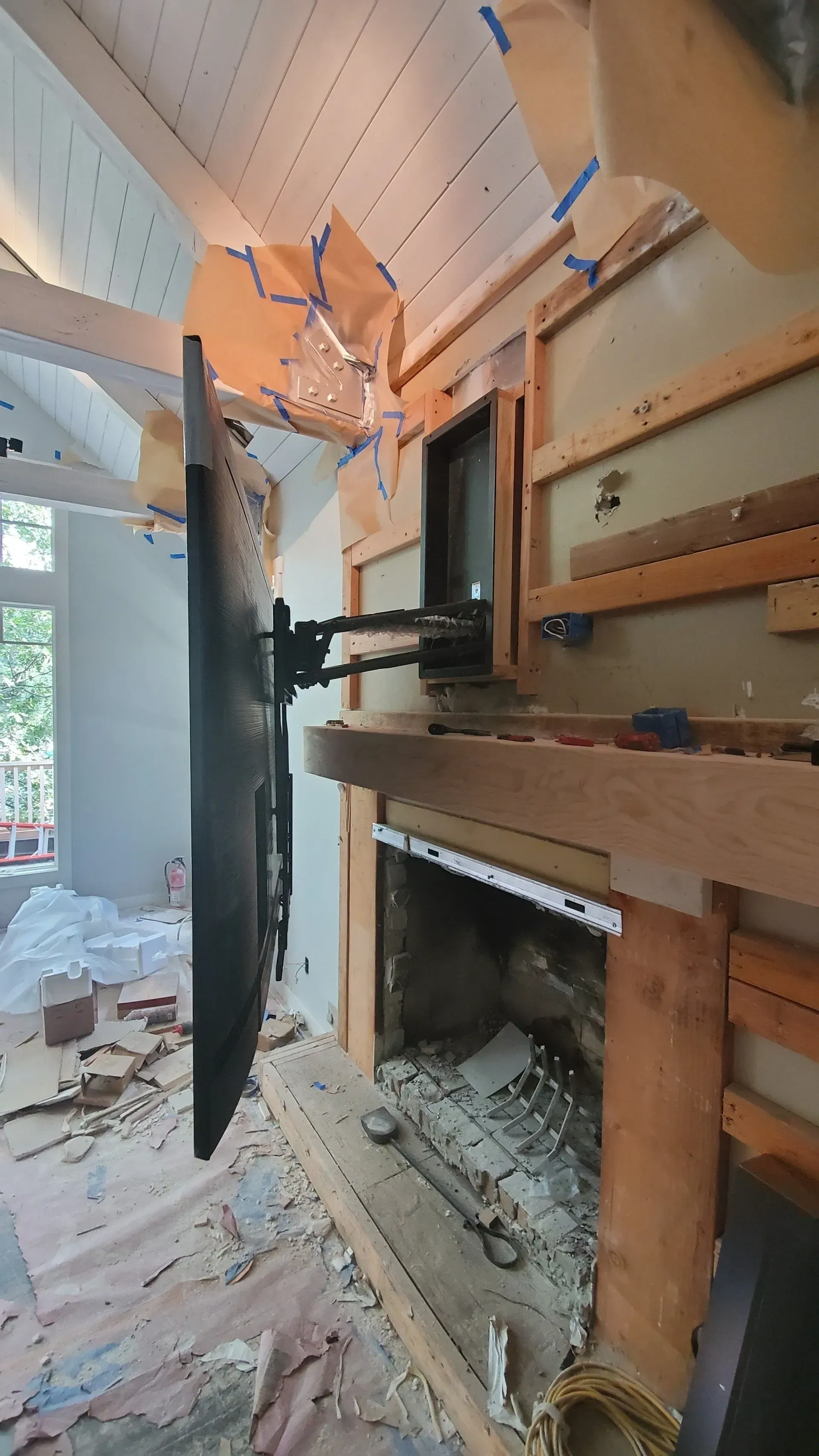 A flat screen tv is mounted to the wall above a fireplace.