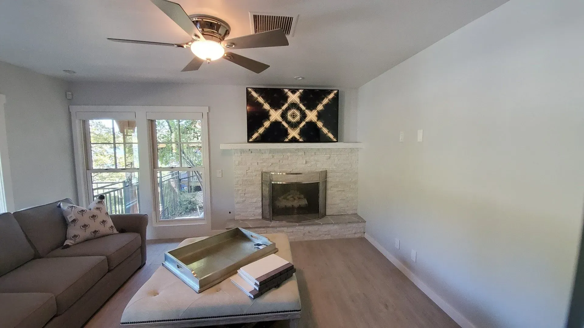 A living room with a fireplace and a ceiling fan