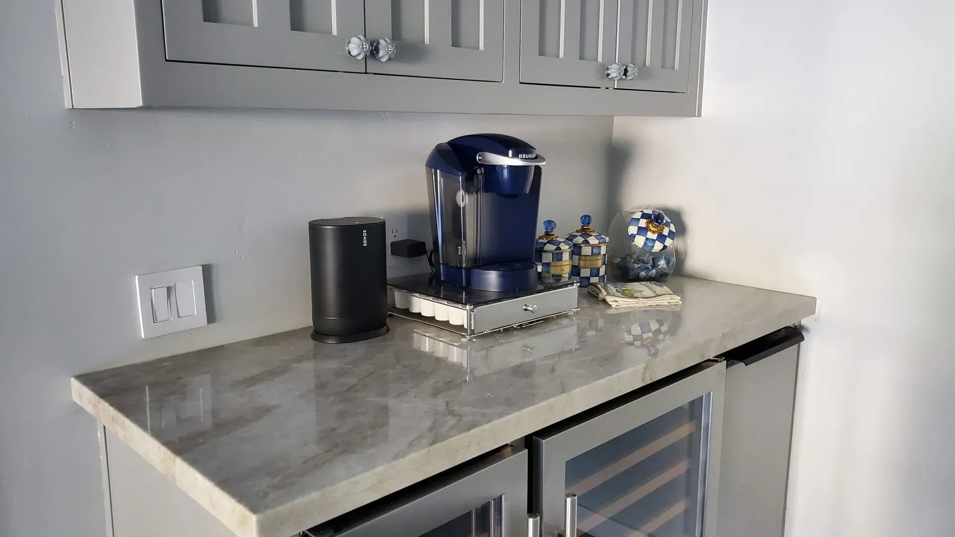 A kitchen counter with a coffee maker and a wine cooler.