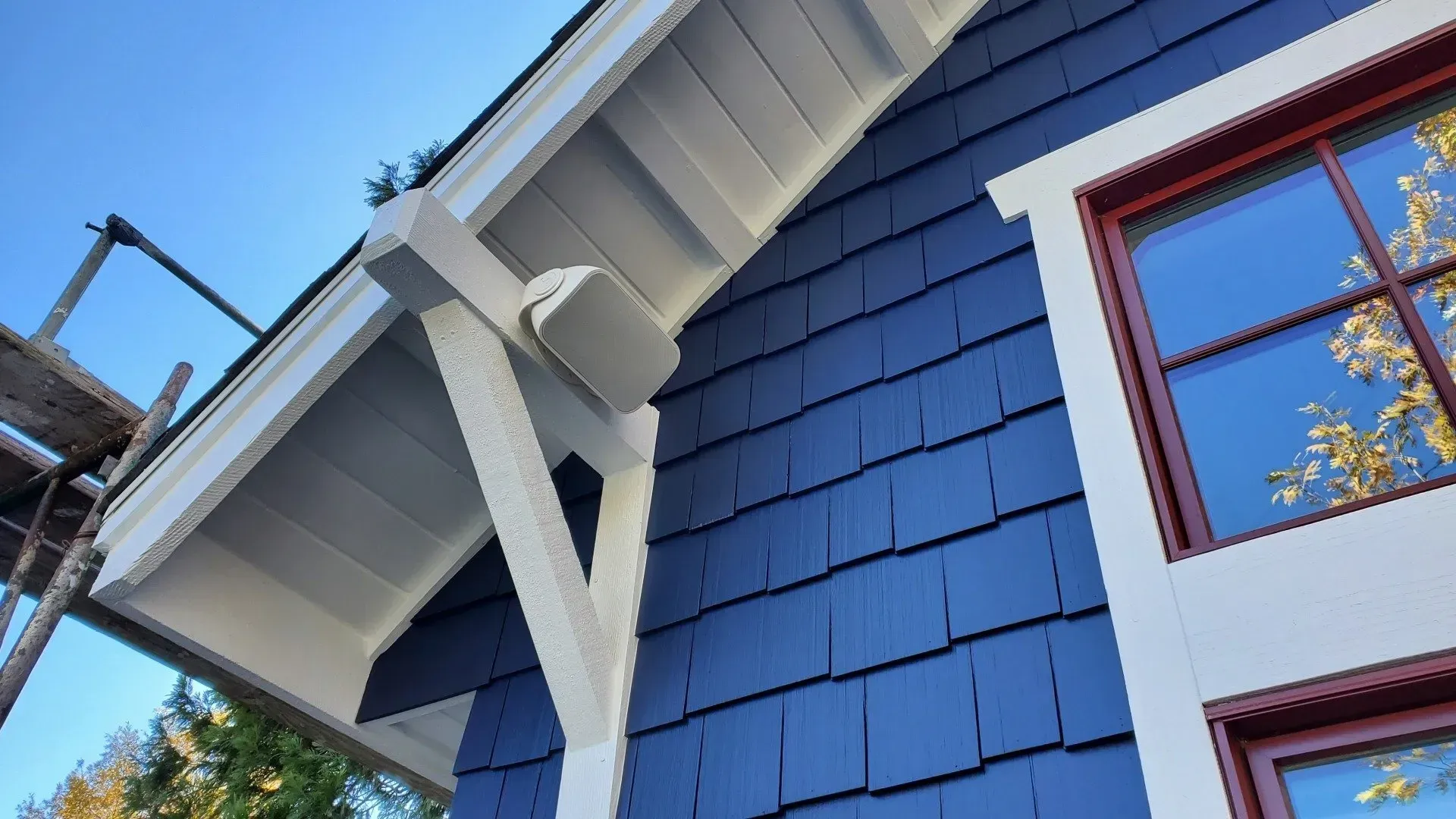 A blue house with white trim and red windows