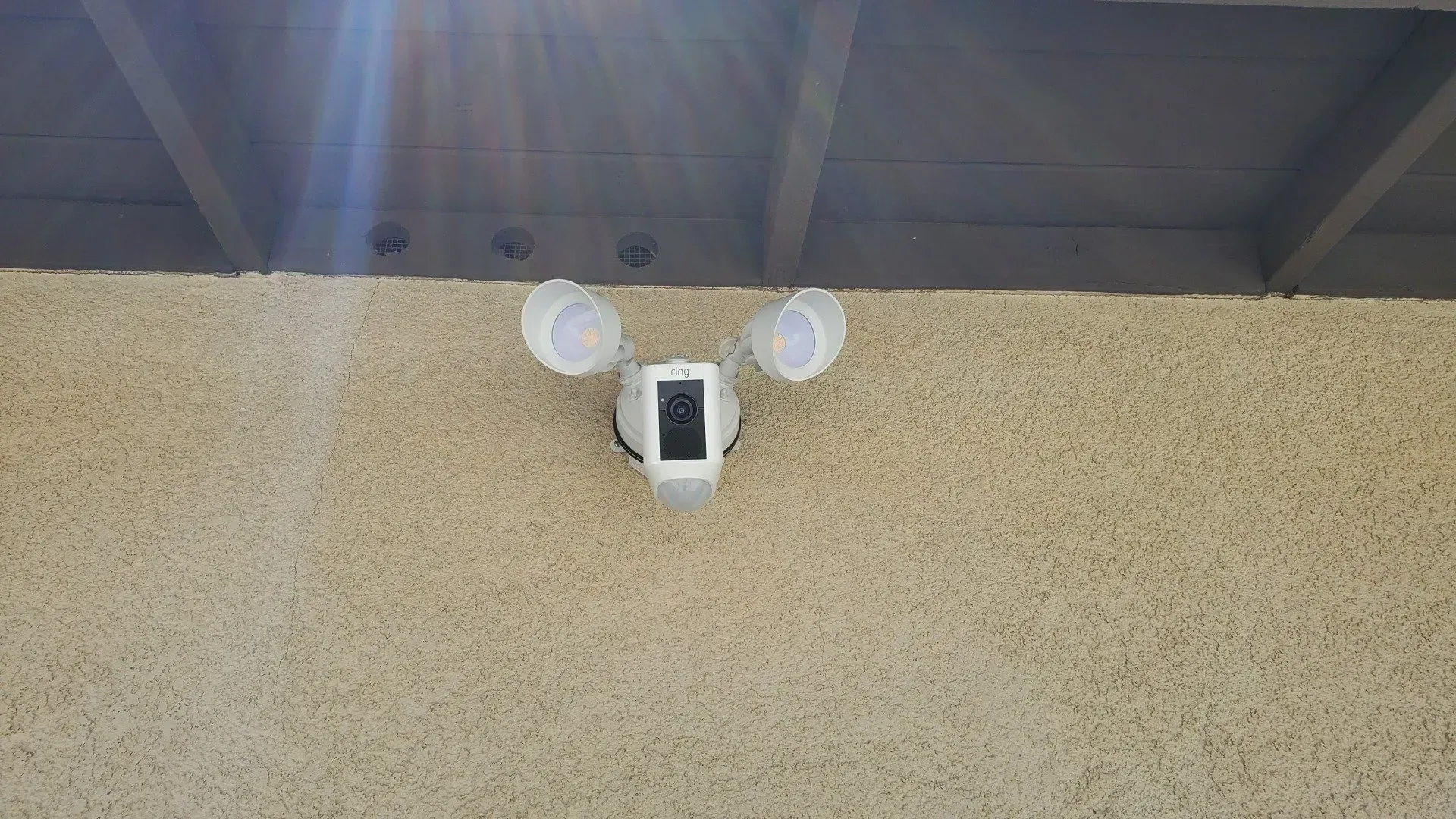 A security camera is mounted on the side of a building.