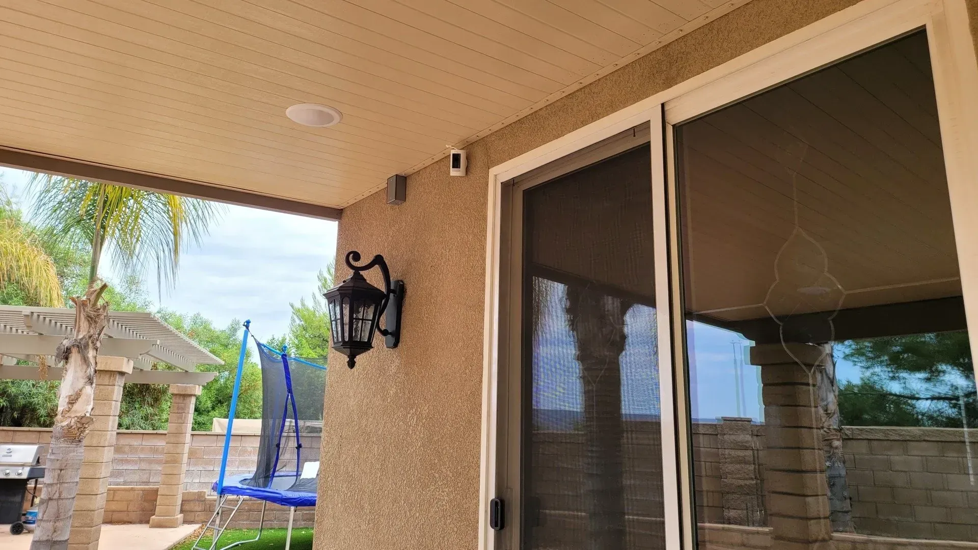 A house with a sliding glass door and a trampoline in the backyard.