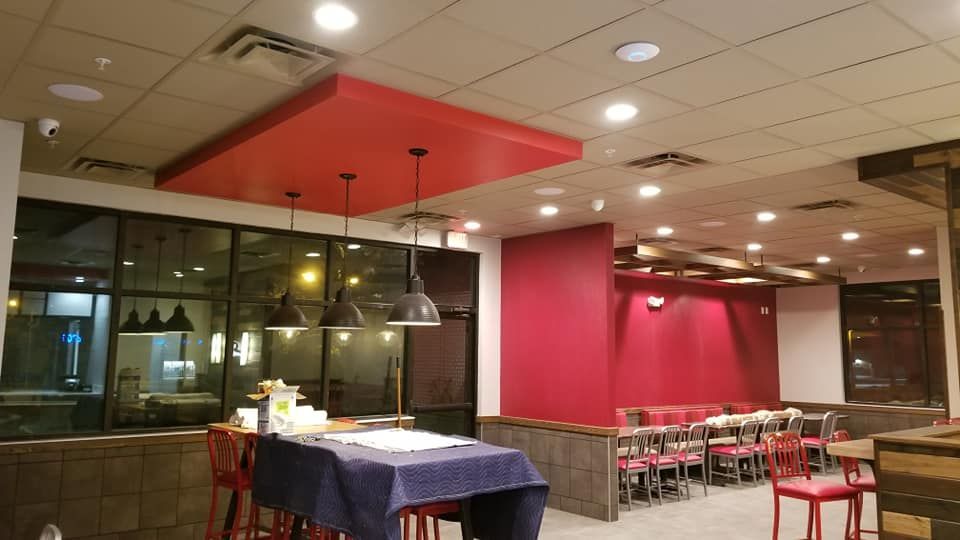 A restaurant with red walls and tables and chairs