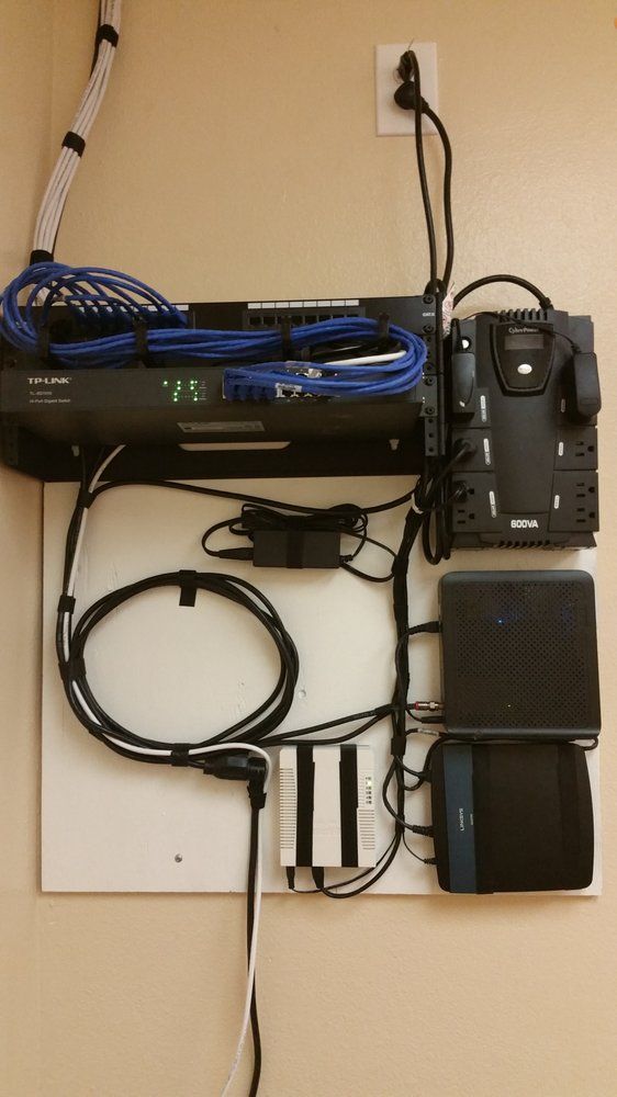 A wall with a bunch of wires hanging from it