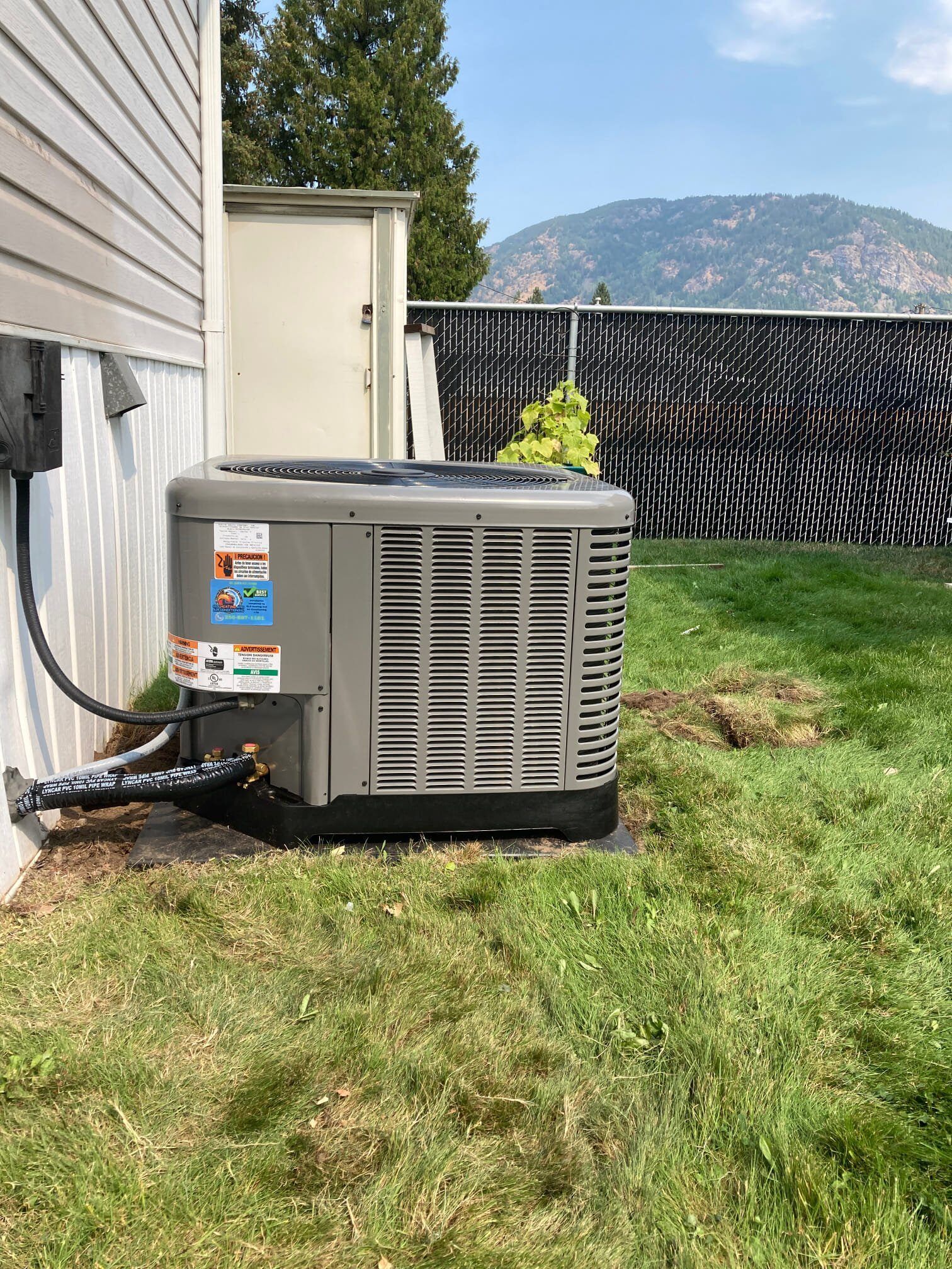 An air conditioner is sitting on the side of a house.