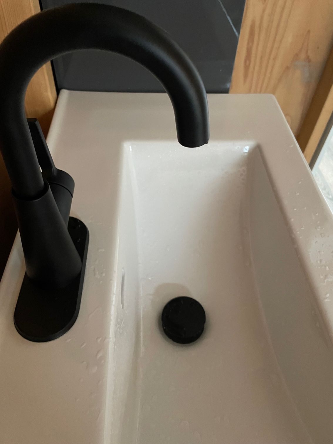 A black faucet is sitting on top of a white sink.