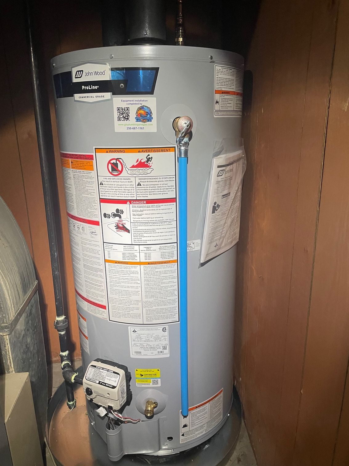 A water heater is sitting in a room next to a wall.