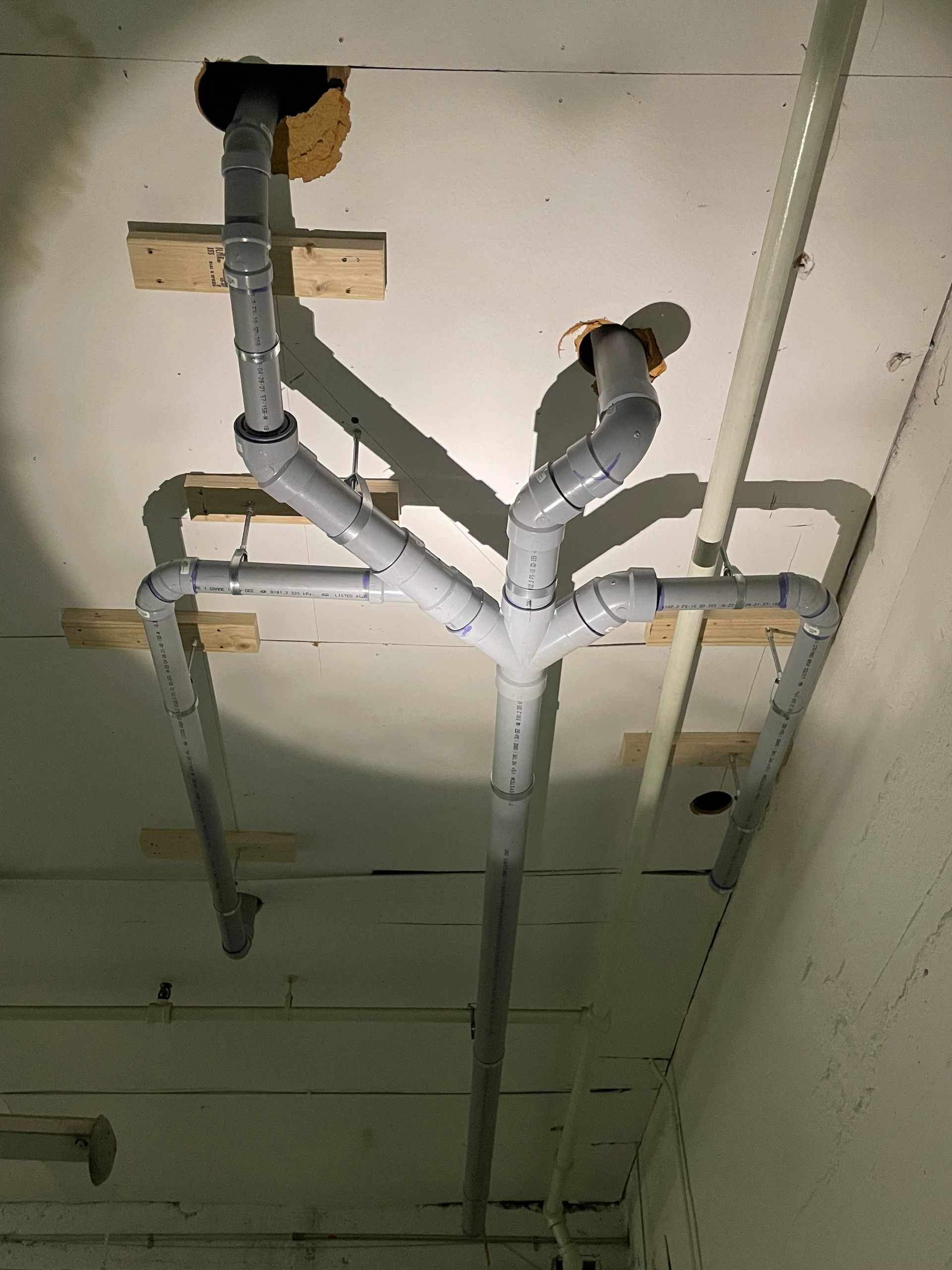 A ceiling with a lot of pipes hanging from it