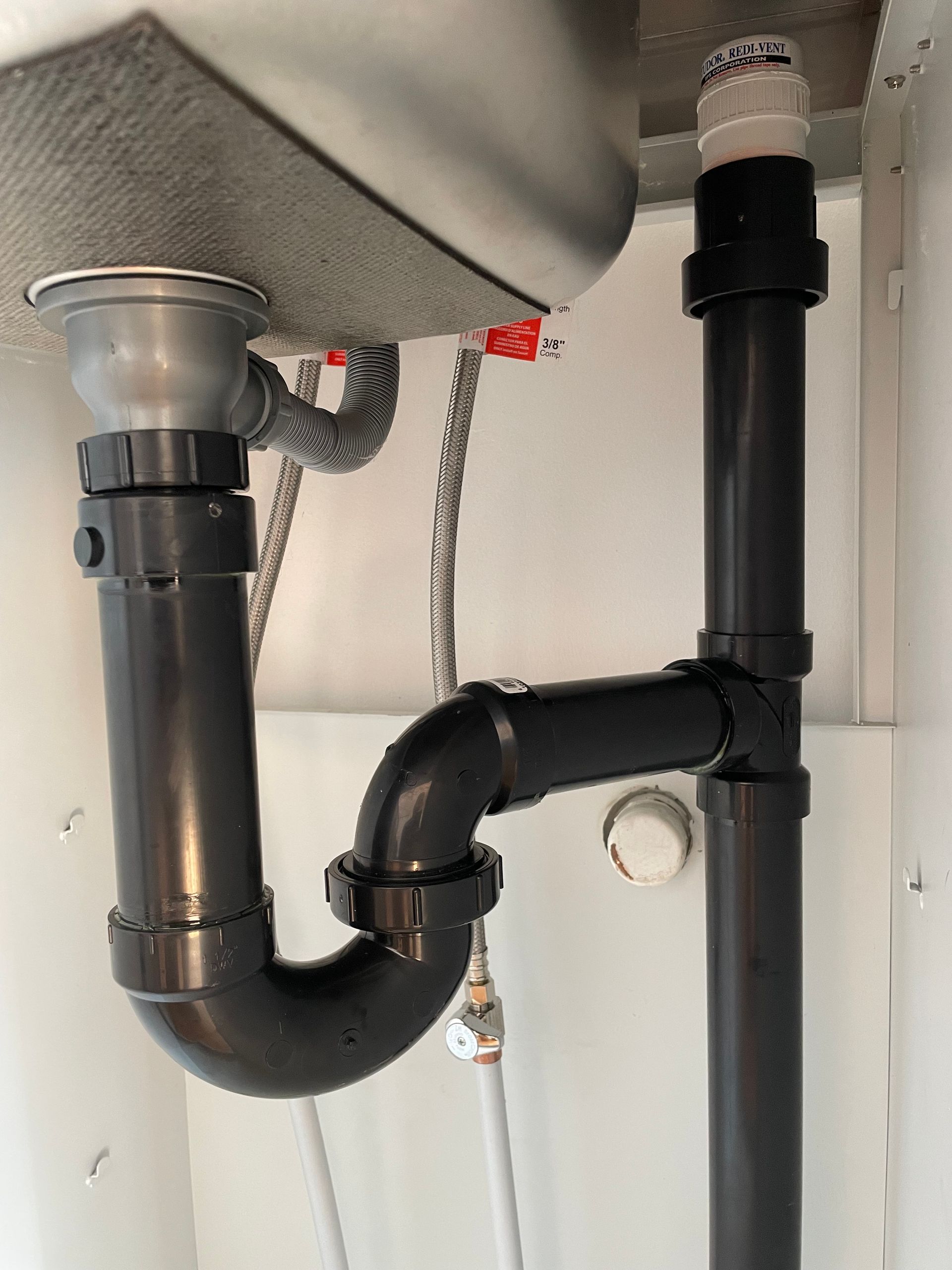 A sink with a black pipe underneath it