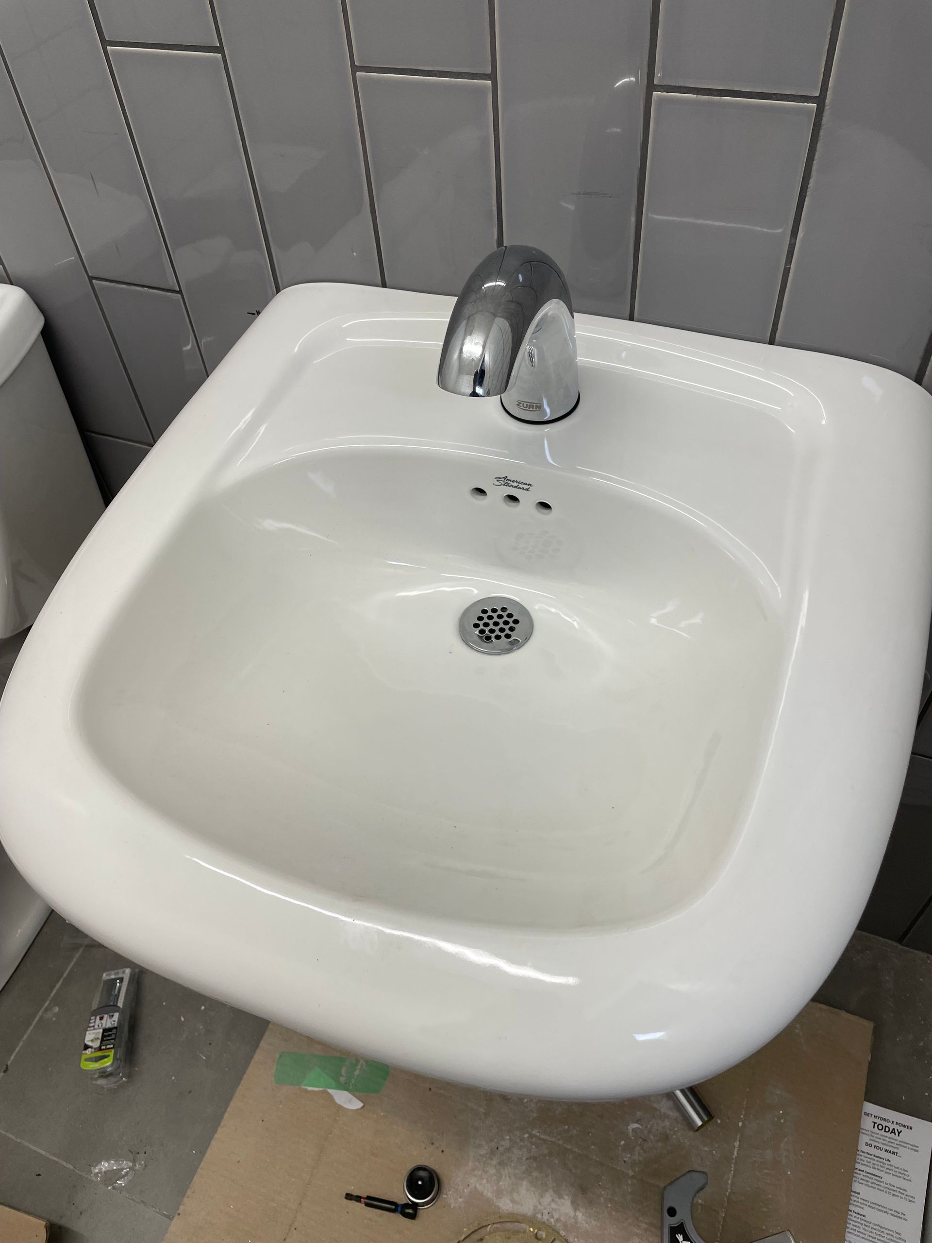 A white bathroom sink is sitting on top of a cardboard box.