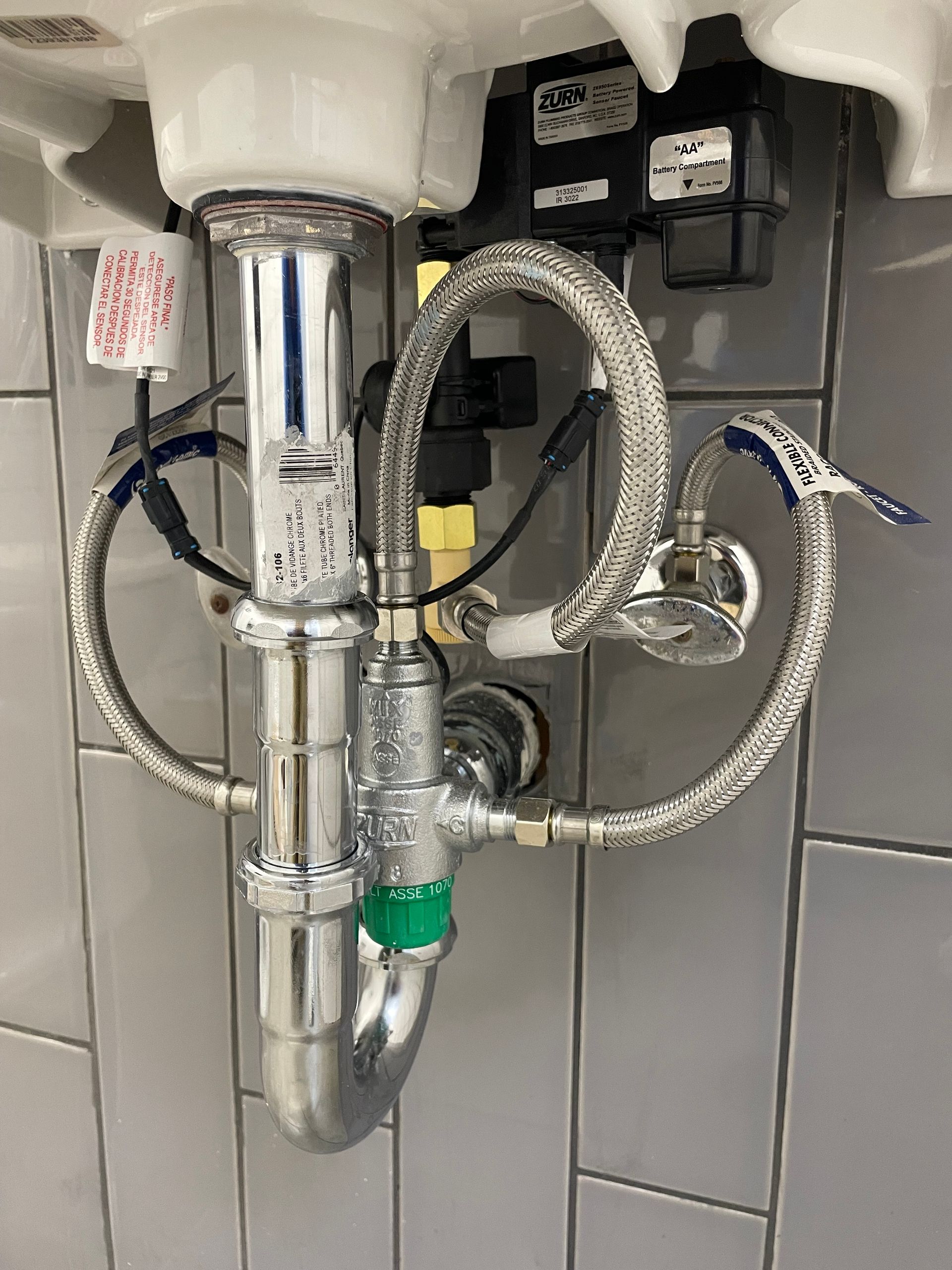 A close up of a sink with a hose attached to it.