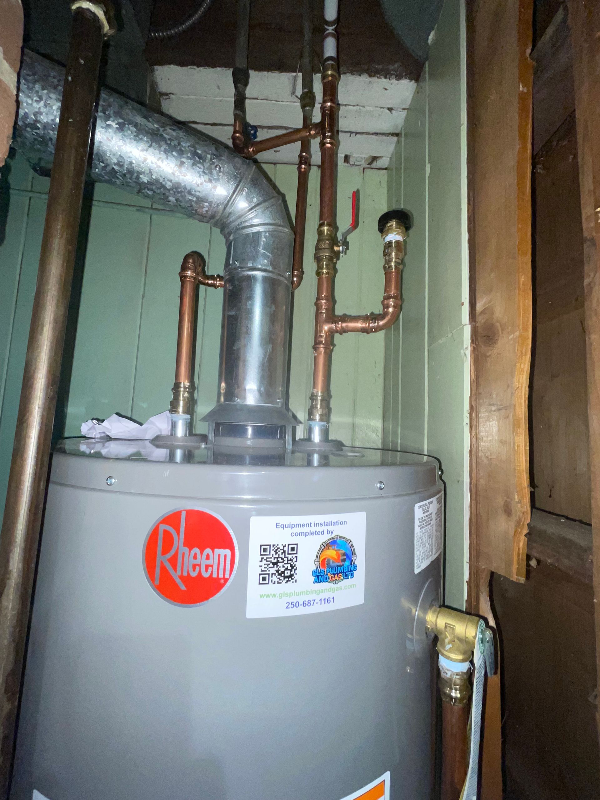 A rheem water heater is sitting in a corner of a room