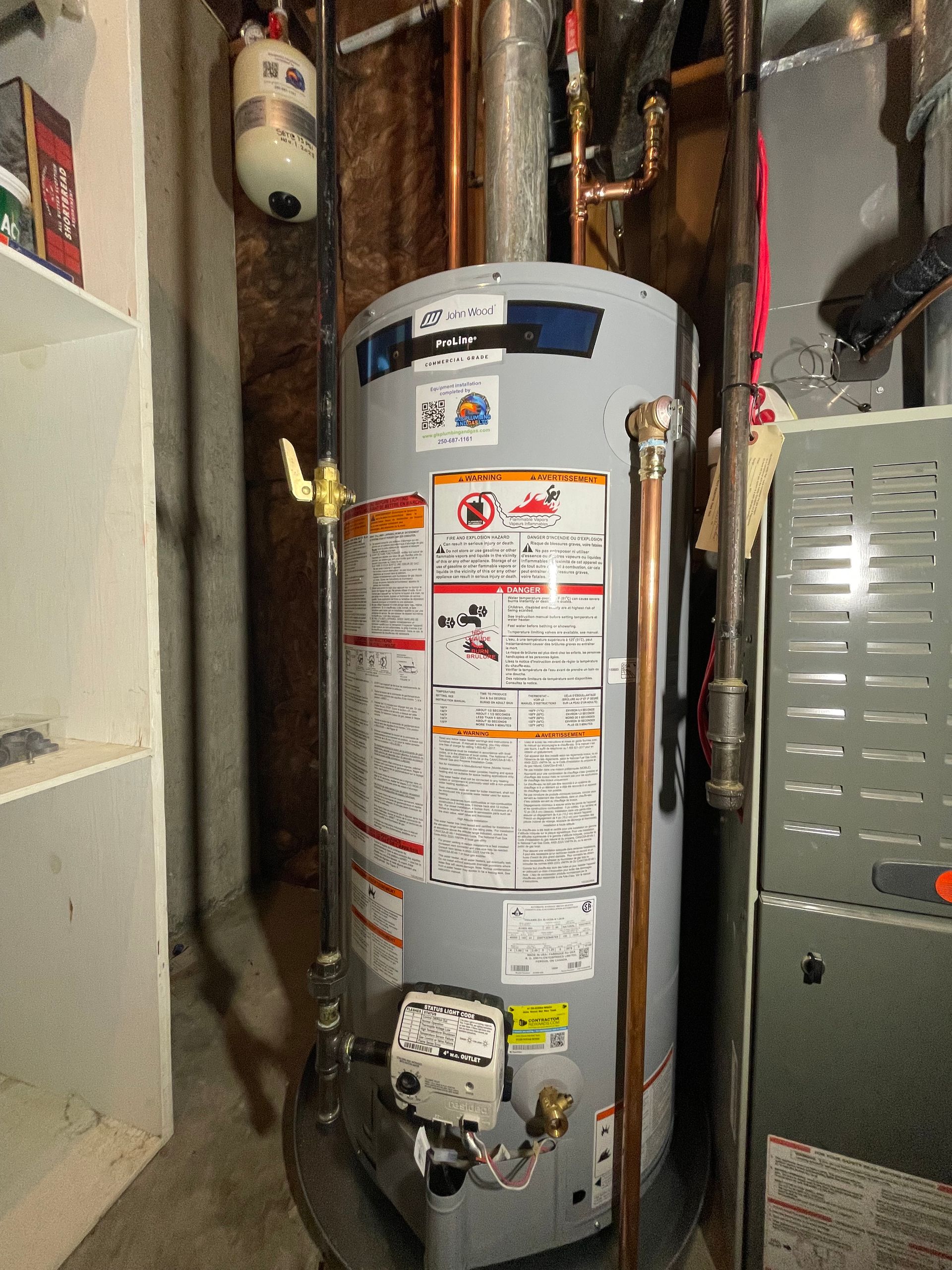 A water heater is sitting in a room next to a furnace.