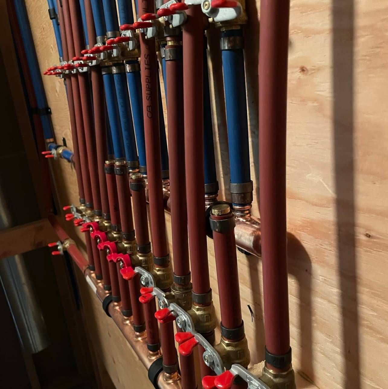 A bunch of pipes are lined up on a wall