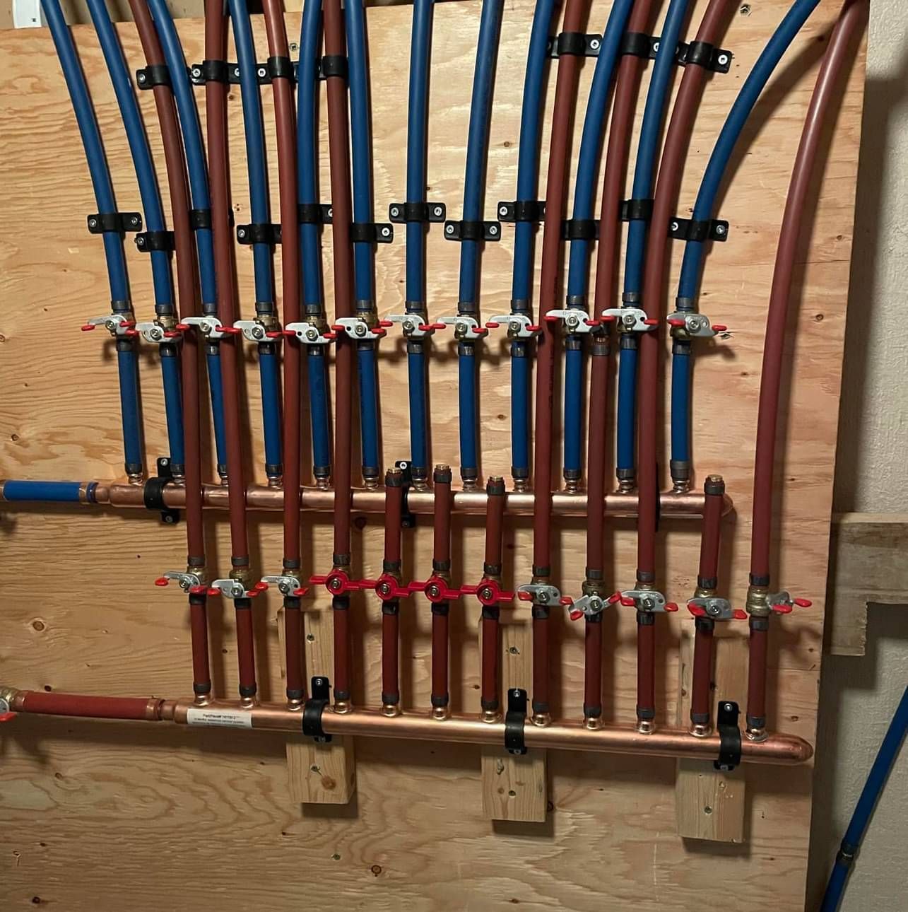 A bunch of pipes are hanging on a wooden wall