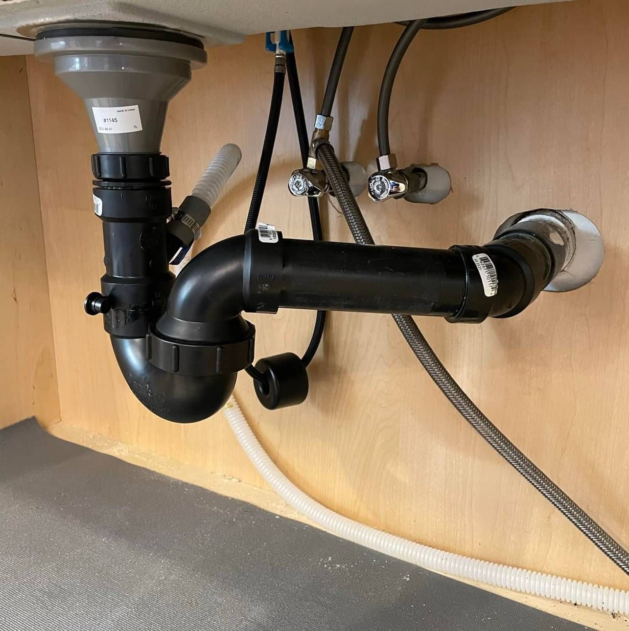 A sink with a black pipe underneath it