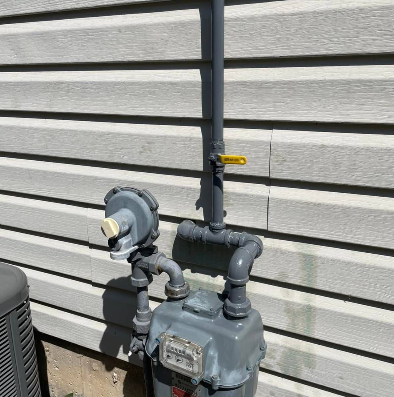A gas meter is attached to the side of a house.