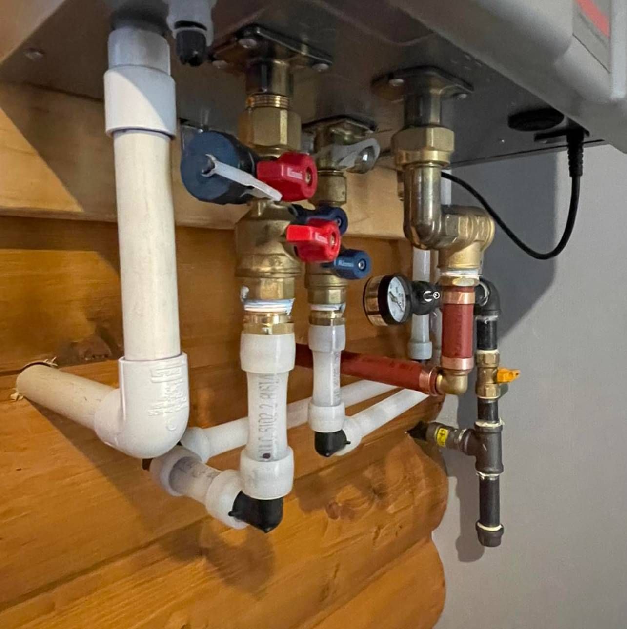 A bunch of pipes are attached to a wall