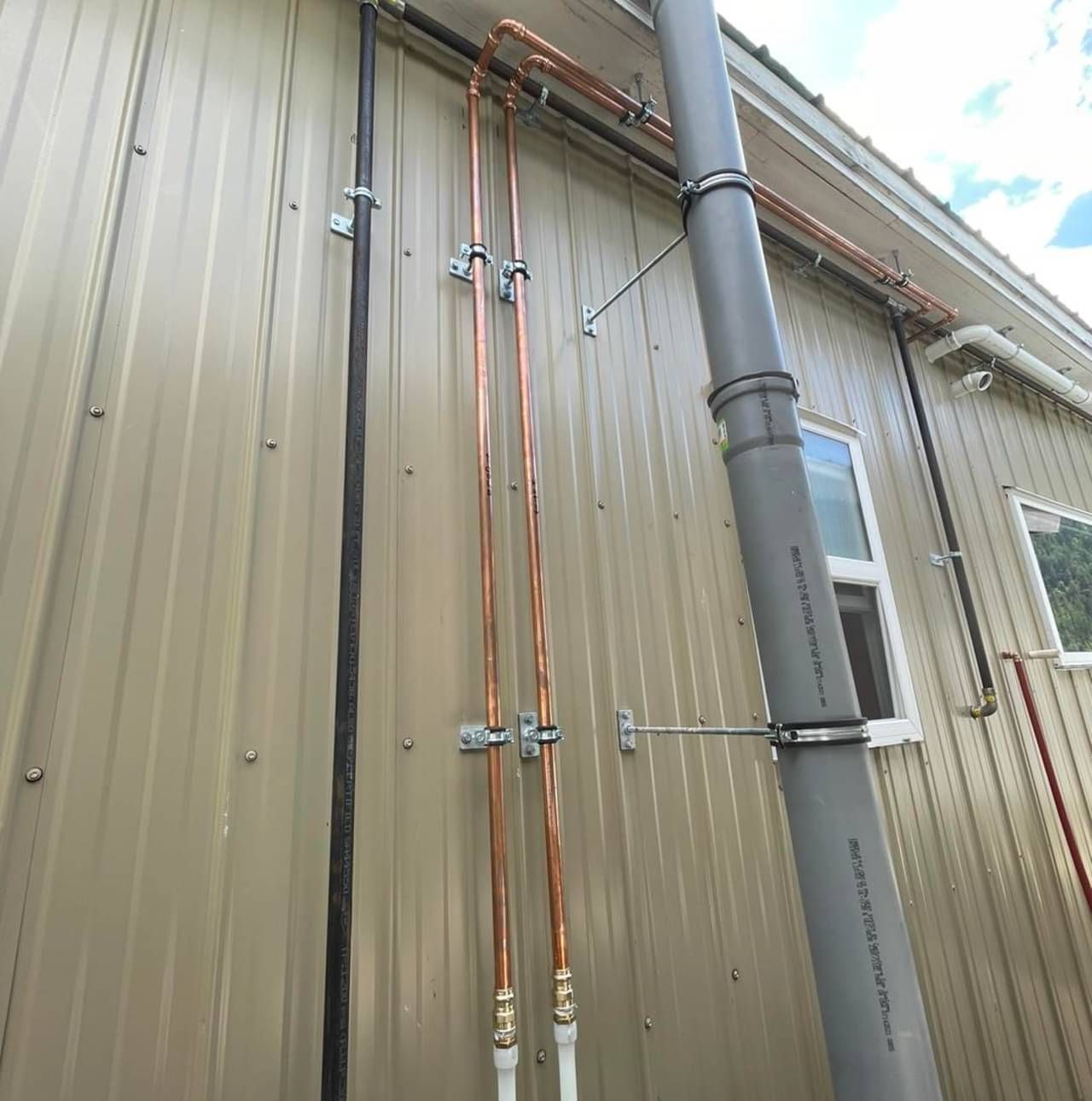 A large pipe is attached to the side of a building.