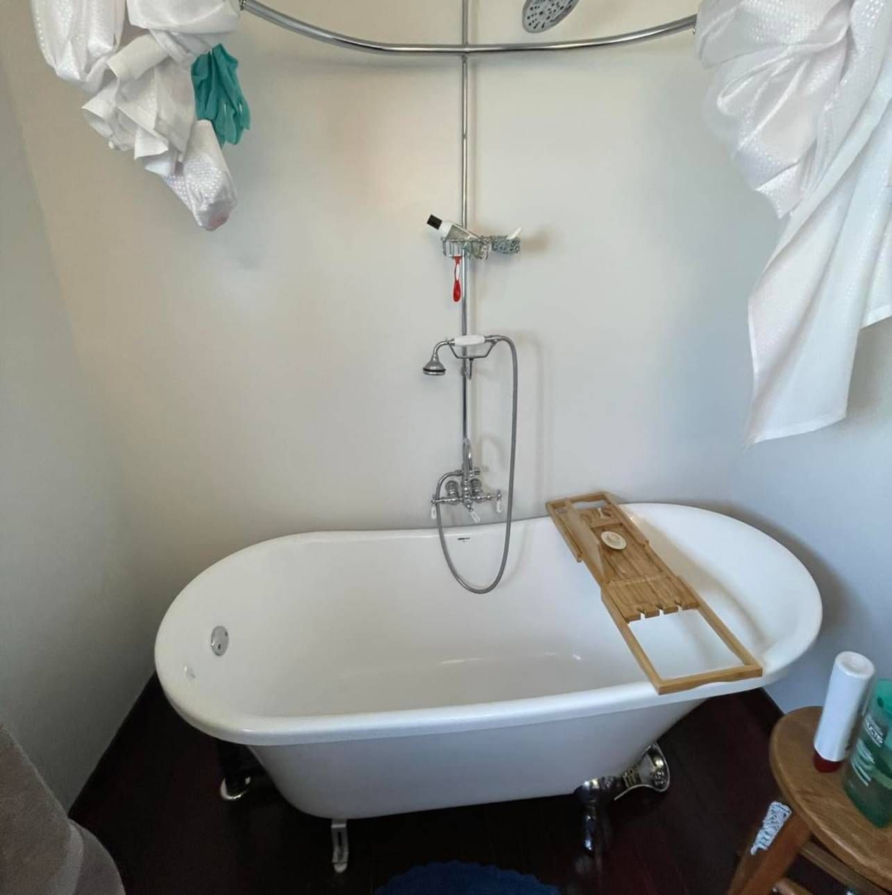 A bathtub with a wooden bathtub tray on top of it