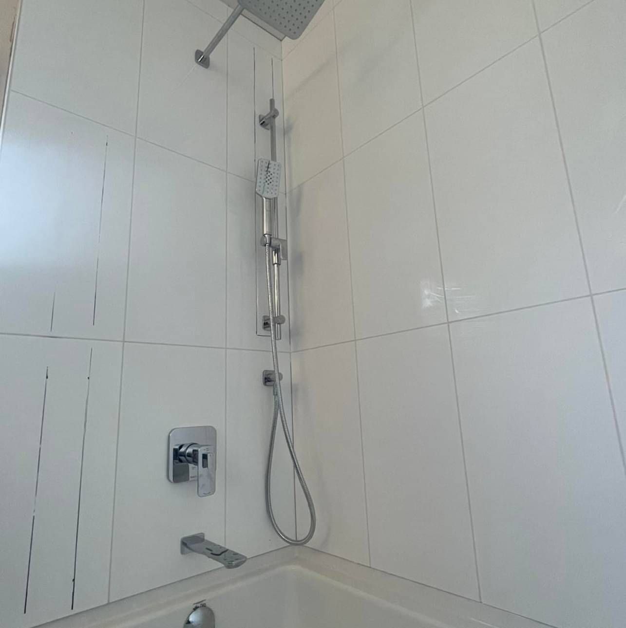 A bathroom with a bathtub and a shower head