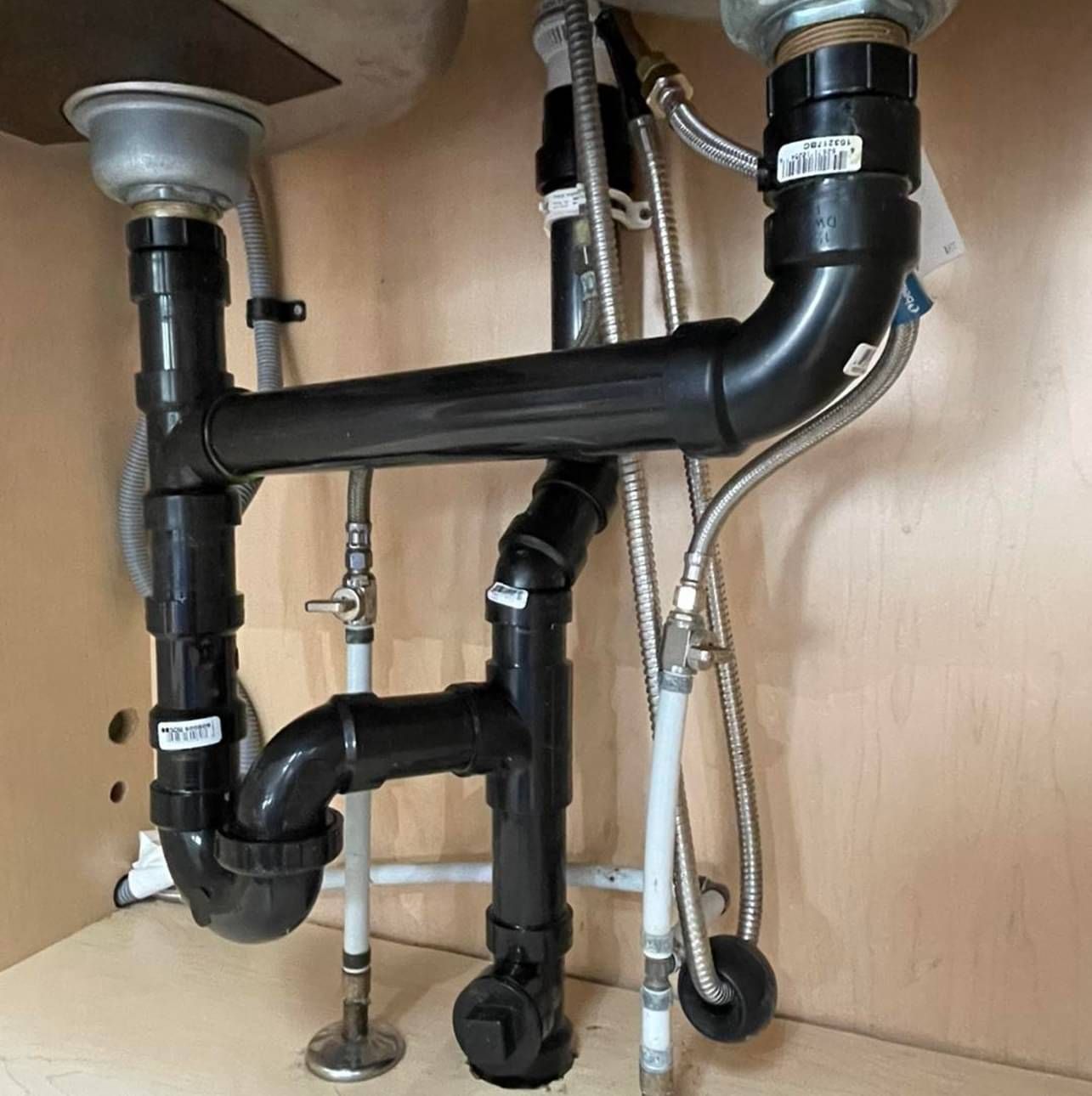 A sink with a lot of pipes underneath it