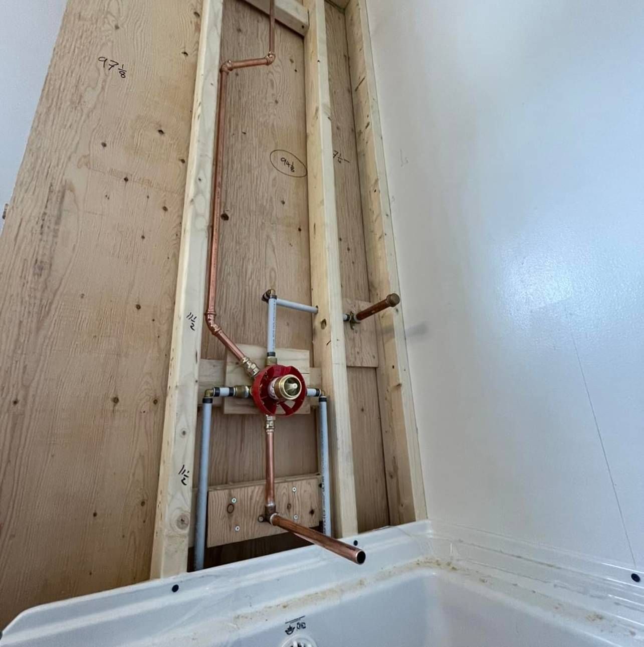 A bathroom with a faucet and pipes coming out of the wall.