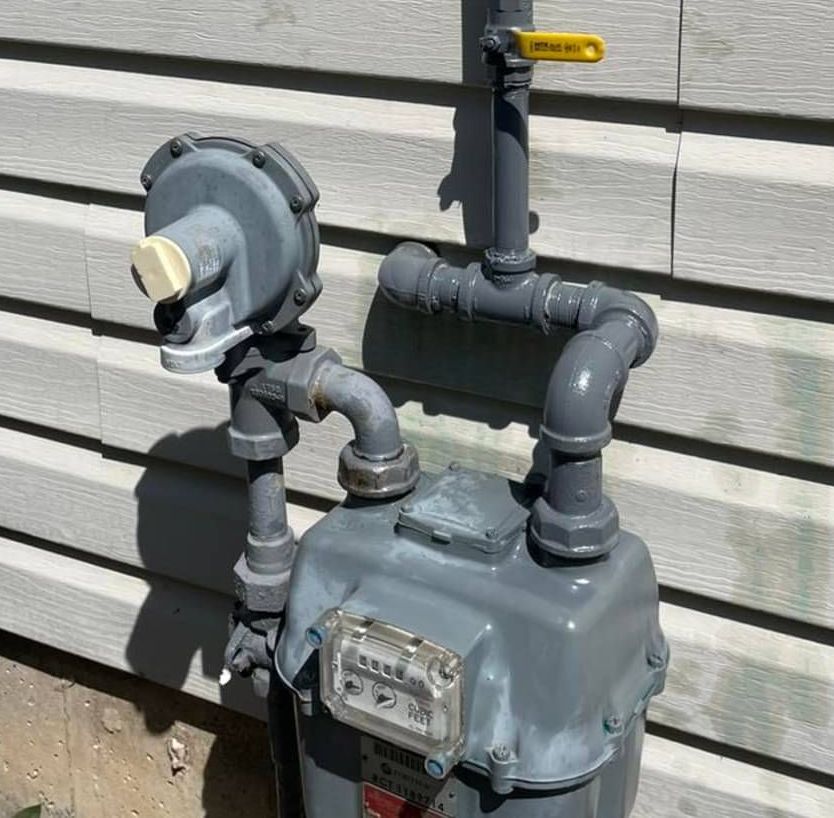 A gas meter is attached to the side of a house