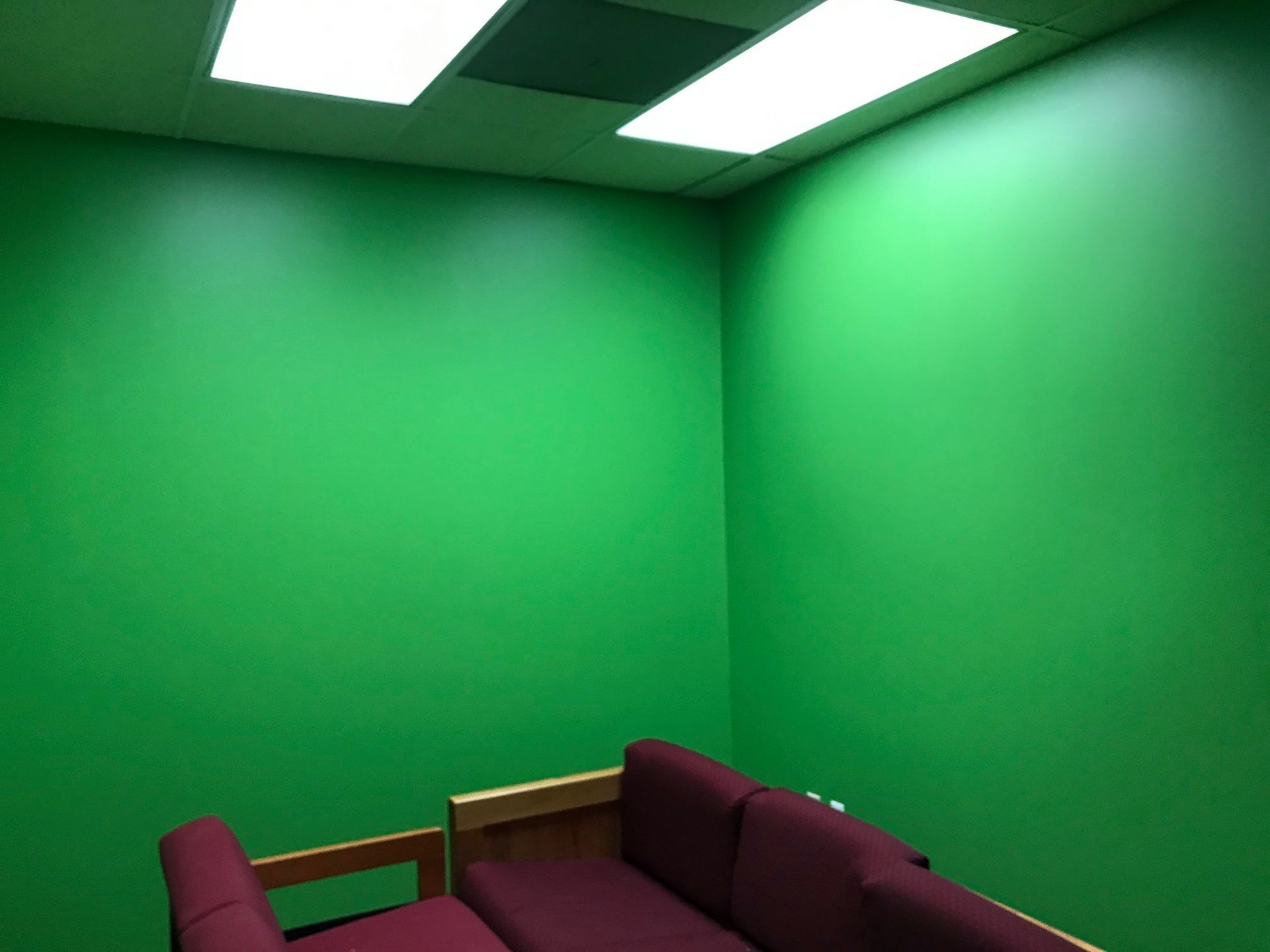 A room with green walls and a red couch