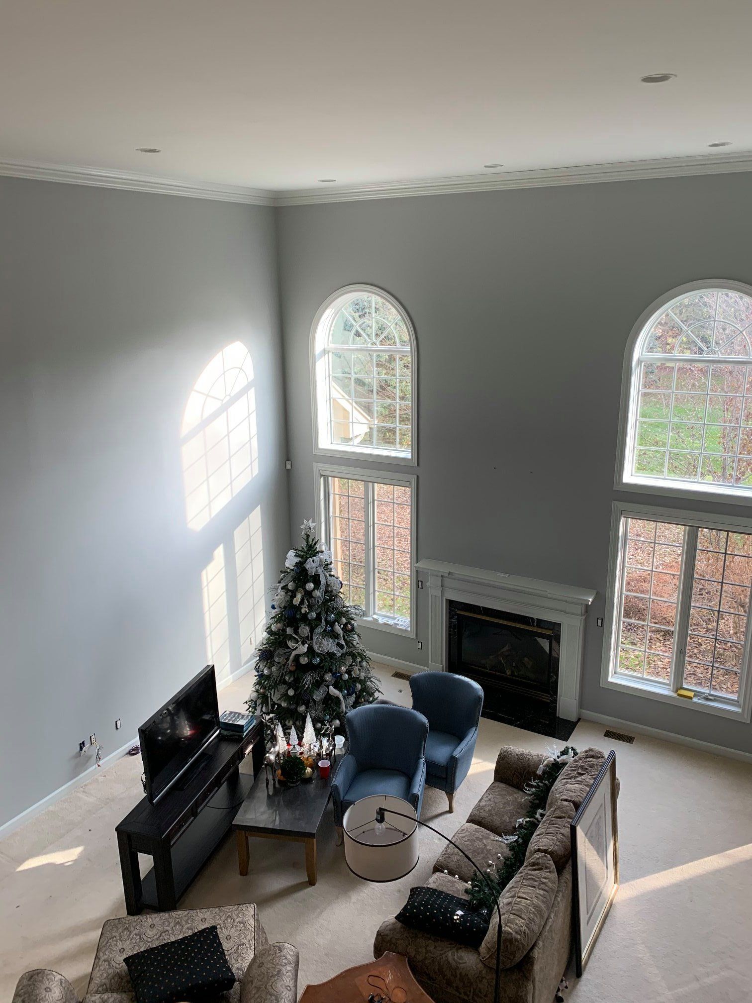 A living room with a couch , chairs , a fireplace and a christmas tree.
