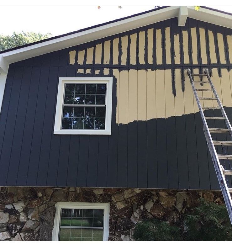 A house that is being painted dark blue by the experts at Blue Sky Pro Painting