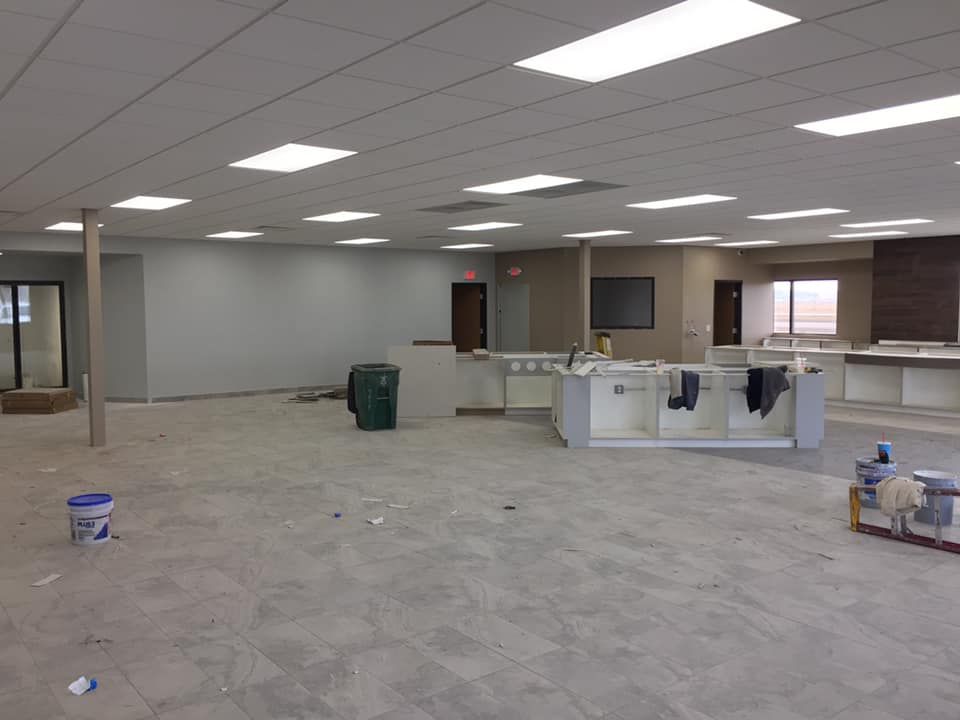 A large empty room with a bucket of paint on the floor