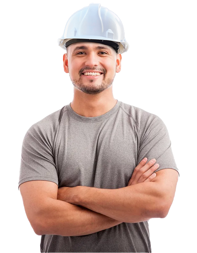 A man wearing a hard hat is smiling with his arms crossed