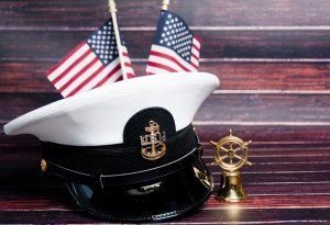 ship captain hat next to two mini american flags